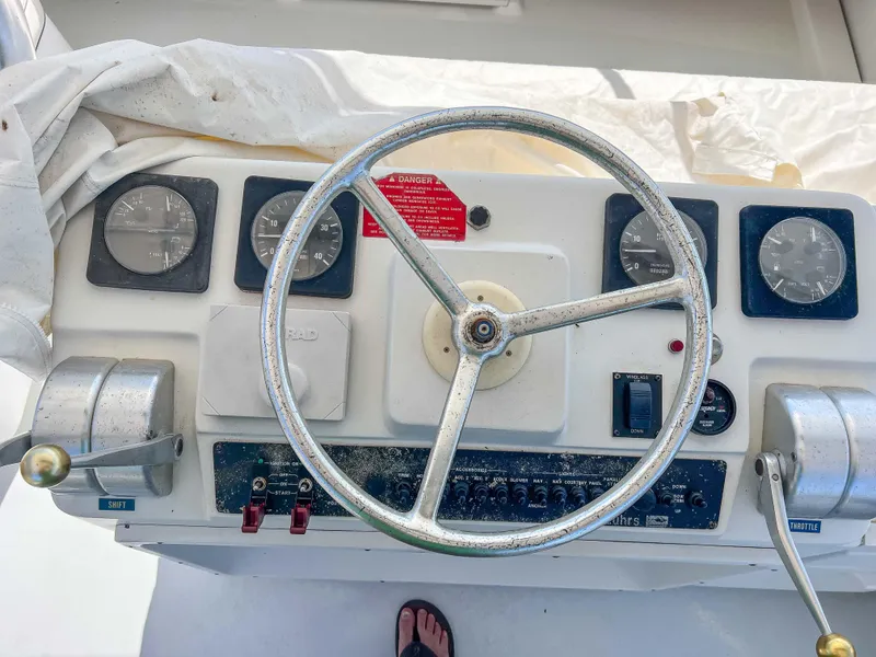 Slide: The Image of 2000 Luhrs 400 Convertible boat helm with steering wheel and control panel. - 17