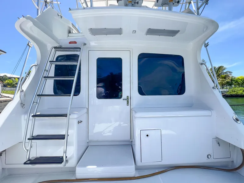 Slide: The Image of Luhrs 400 Convertible 2000 model, rear view with ladder and door, docked by water. - 19