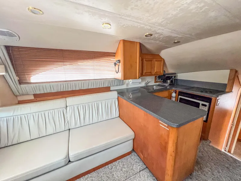 Slide: The Image of Interior of 2000 Luhrs 400 Convertible yacht with kitchen and seating area. - 25