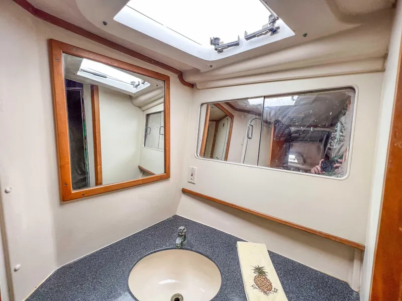 Slide: The Image of Bathroom vanity area in a 2000 Luhrs 400 Convertible boat with mirrors and sink. - 28