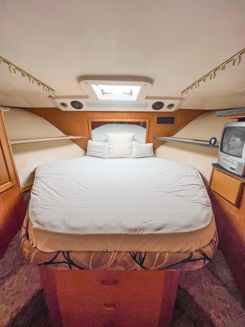 Slide: The Image of 2000 Luhrs 400 Convertible boat cabin with bed and TV. - 29