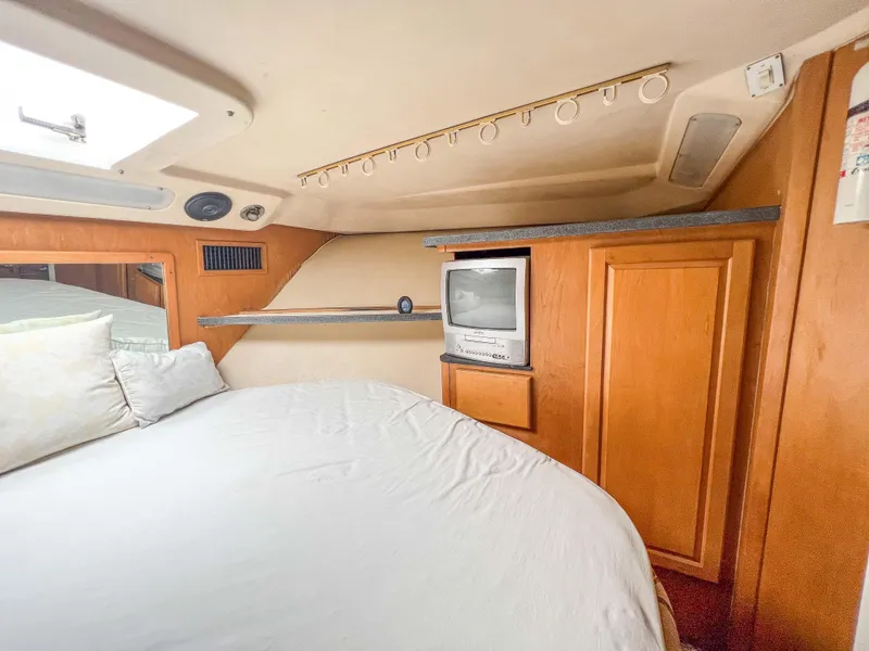 Slide: The Image of Luhrs 400 Convertible 2000 model bedroom with TV and storage cabinets. - 31