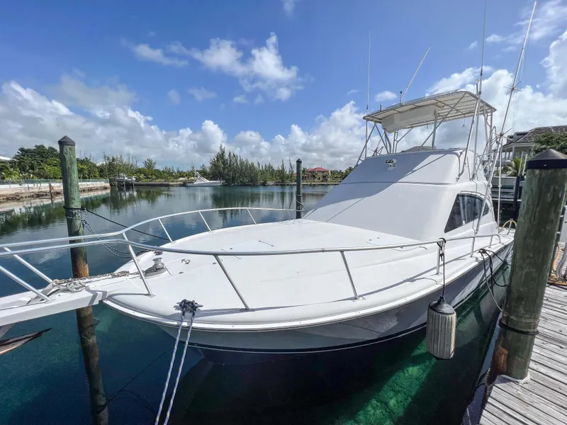 Slide: The Image of 2000 Luhrs 400 Convertible yacht docked in a serene marina. - 4