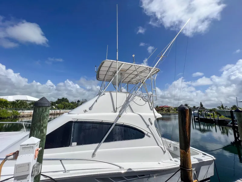 Slide: The Image of 2000 Luhrs 400 Convertible boat docked at a marina under a clear blue sky. - 6