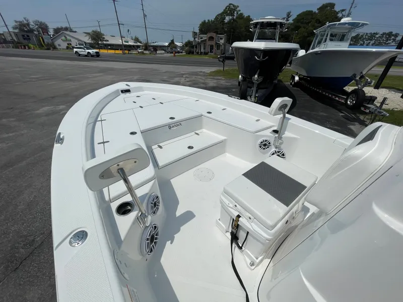 Slide: The Image of 2023 BlackJack 256 Bay boat interior, white deck with seating and storage compartments. - 15