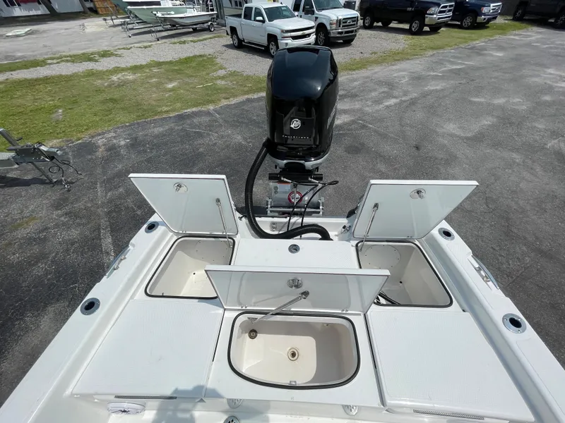Slide: The Image of 2023 BlackJack 256 Bay boat with open storage compartments and outboard motor. - 18