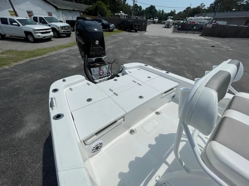 Slide: The Image of 2023 BlackJack 256 Bay boat with outboard motor, white deck, and seating. - 7
