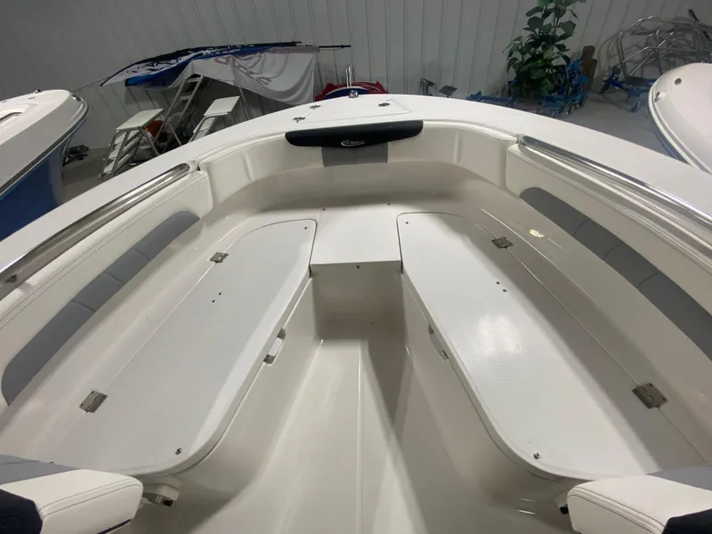Slide: The Image of 2024 Robalo R202 Explorer boat interior with white seating and storage compartments. - 16