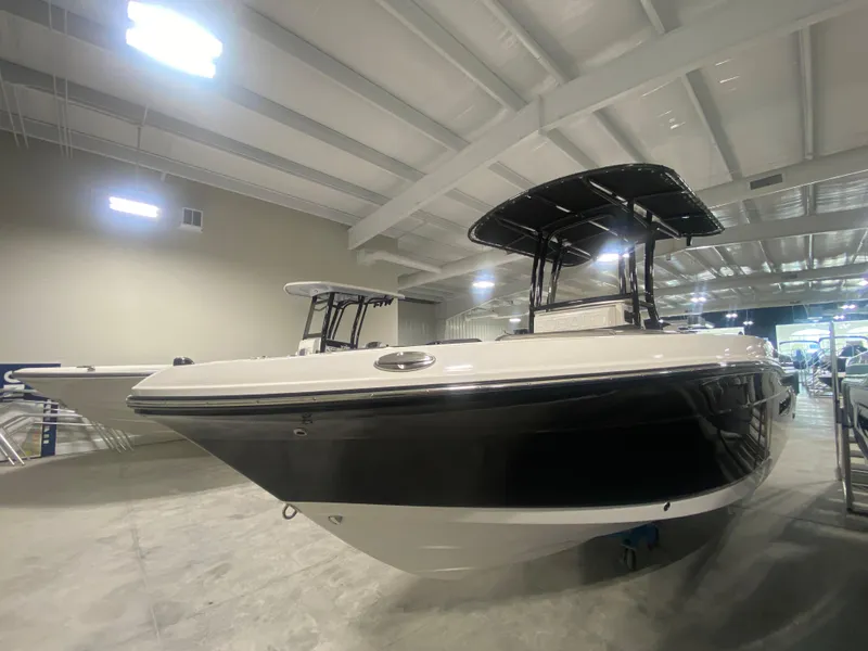 Slide: The Image of 2024 Robalo R202 Explorer boat in showroom, black and white exterior. - 3