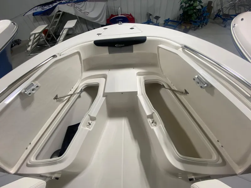 Slide: The Image of 2024 Robalo R202 Explorer boat bow storage compartments in a showroom. - 17