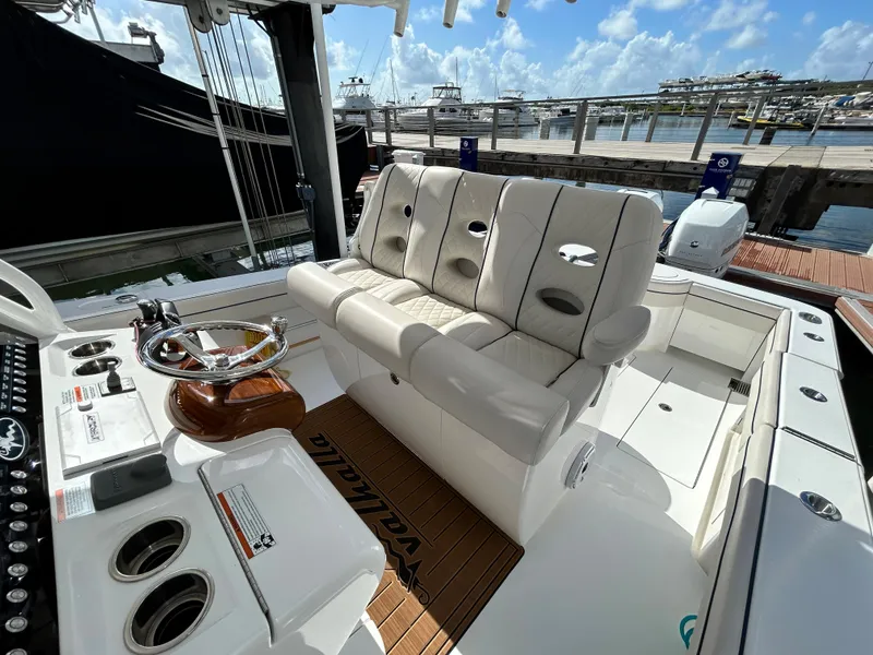 Slide: The Image of 2022 Valhalla Boatworks V-33 interior with plush seating and modern helm controls at a marina. - 2