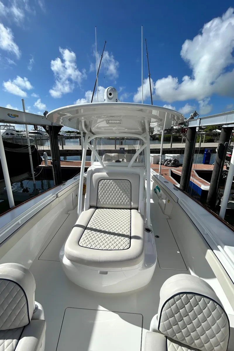 Slide: The Image of 2022 Valhalla Boatworks V-33 with cushioned seating, docked under a clear blue sky. - 9