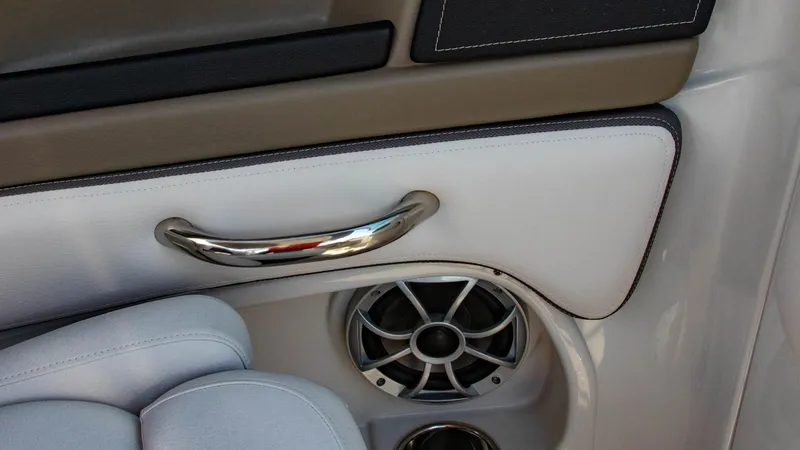 Slide: The Image of Interior detail of 2023 Crownline 290 XSS boat, featuring a speaker and chrome handle. - 26