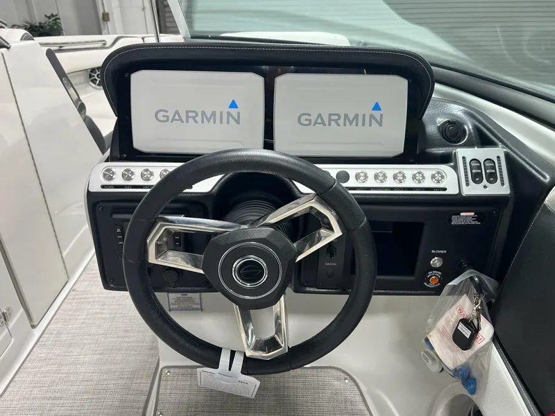 Slide: The Image of 2023 Crownline 290 SS boat dashboard with dual Garmin displays and modern steering wheel. - 6