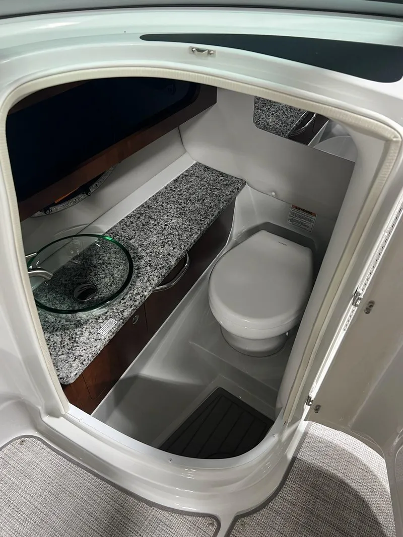 Slide: The Image of 2023 Crownline 290 SS boat bathroom with granite countertop and modern fixtures. - 9