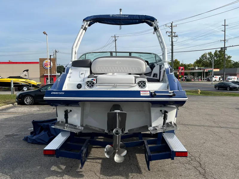 Slide: The Image of 2023 Crownline 260 SS SURF boat, rear view, parked on a trailer in a parking lot. - 3