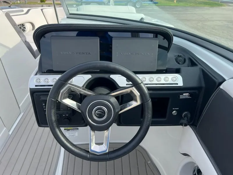 Slide: The Image of 2023 Crownline 260 SS SURF boat dashboard with steering wheel and dual displays. - 6