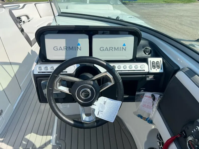 Slide: The Image of 2023 Crownline 260 SS boat dashboard with dual Garmin displays and steering wheel. - 3