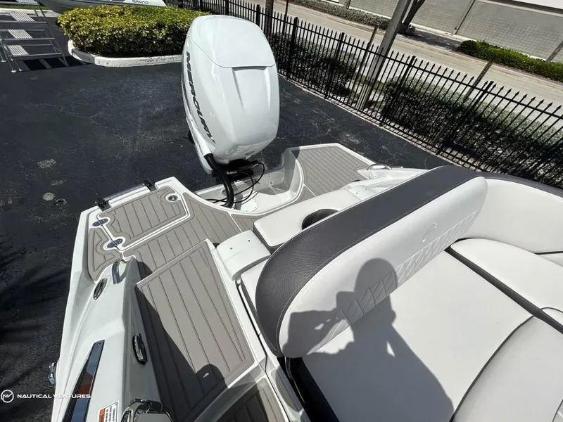 Slide: The Image of 2024 Crownline E290 XS boat with outboard motor and spacious seating. - 13