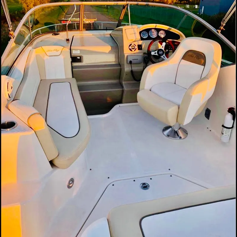 Slide: The Image of 2012 Sea Ray 240 Sundancer boat interior with seating and steering wheel. - 4