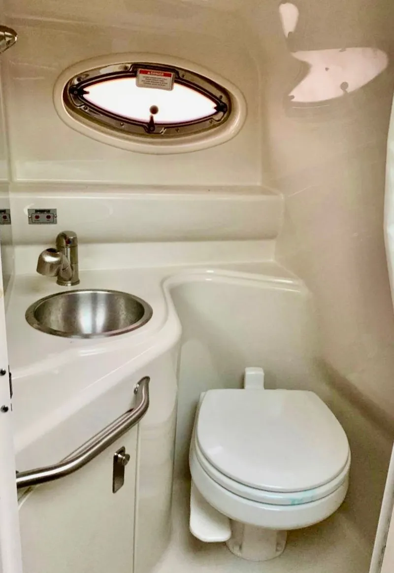 Slide: The Image of Compact bathroom in 2012 Sea Ray 240 Sundancer boat with sink and toilet. - 8