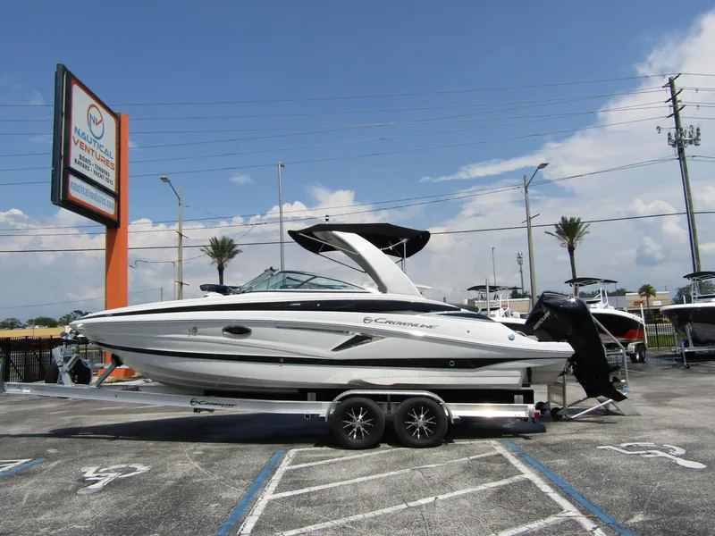 Slide: The Image of 2024 Crownline 270 XSS boat on trailer in parking lot, clear sky background. - 1