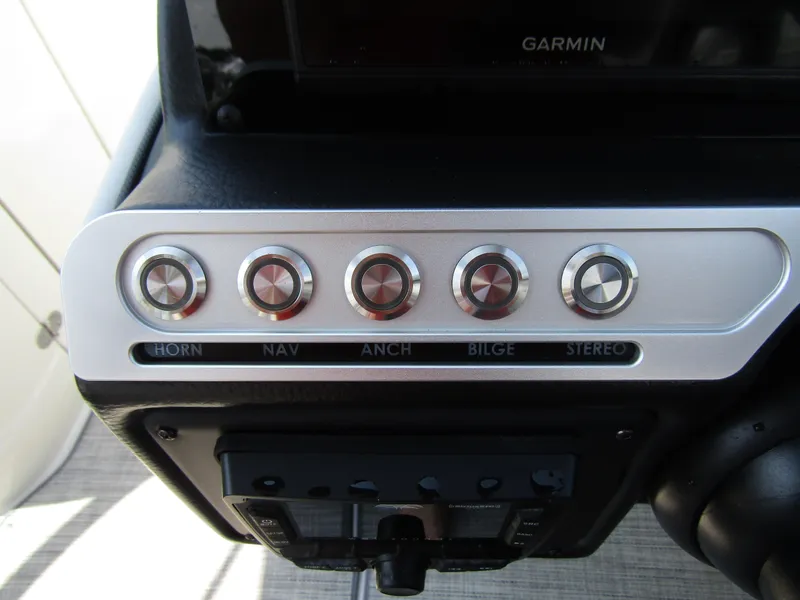 Slide: The Image of 2024 Crownline 270 XSS control panel with buttons for horn, navigation, anchor, bilge, and stereo. - 18