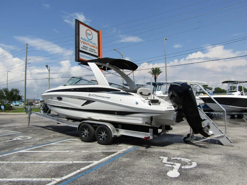 Slide: The Image of 2024 Crownline 270 XSS boat on trailer at dealership parking lot. - 2
