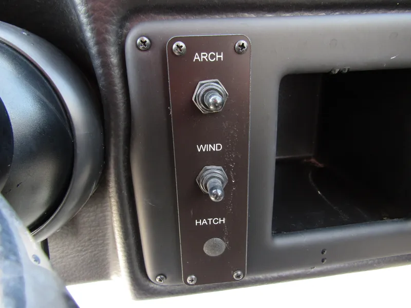 Slide: The Image of Control panel of 2024 Crownline 270 XSS boat with switches for arch, wind, and hatch. - 22