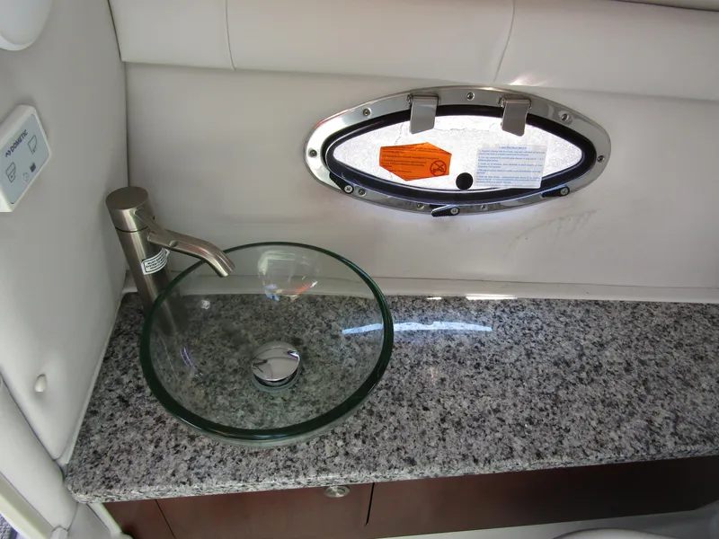 Slide: The Image of 2024 Crownline 270 XSS boat interior with granite countertop and glass sink. - 26