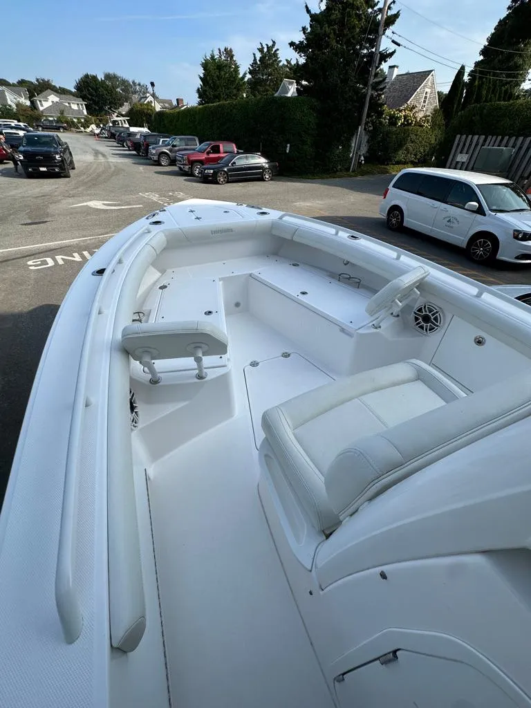 Slide: The Image of 2021 Everglades 253 boat with spacious deck and seating, parked on a street. - 11