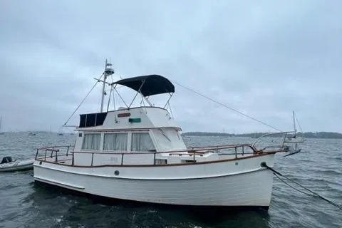 The Image of 1978 Grand Banks Trawler boat anchored on a cloudy day. - 0