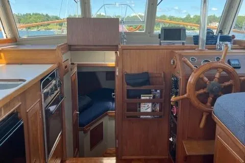 Slide: The Image of 1978 Grand Banks Trawler interior with wooden helm, cozy cabin, and nautical decor. - 13
