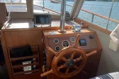 Slide: The Image of 1978 Grand Banks Trawler helm with wooden wheel, gauges, and navigation equipment. - 14