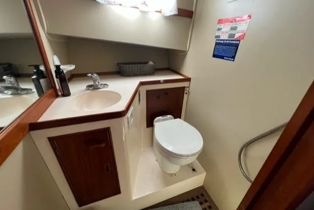 Slide: The Image of Bathroom interior of a 1978 Grand Banks Trawler, featuring sink and toilet. - 22