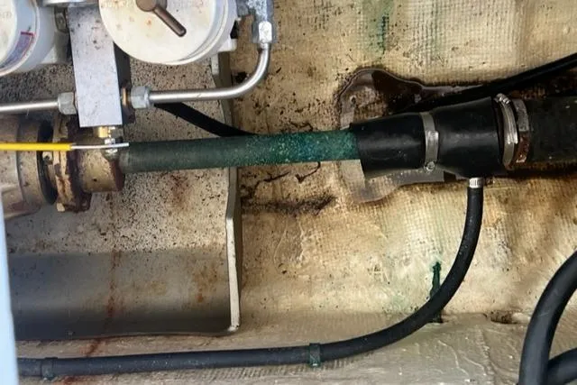 Slide: The Image of 1978 Grand Banks Trawler engine compartment with visible pipes and fittings. - 36