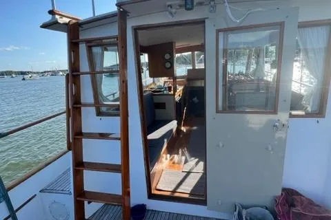 Slide: The Image of 1978 Grand Banks Trawler with open cabin door, docked on a sunny day. - 39