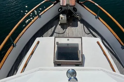 Slide: The Image of 1978 Grand Banks Trawler deck with wooden railings and hatch, on calm water. - 42