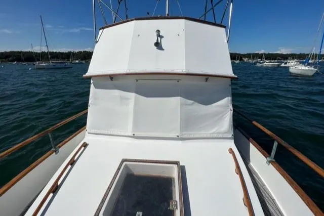 Slide: The Image of 1978 Grand Banks Trawler on water, showcasing deck and cabin, surrounded by other boats. - 45