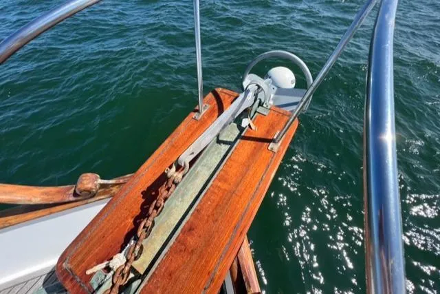 Slide: The Image of 1978 Grand Banks Trawler anchor setup on wooden deck over water. - 48