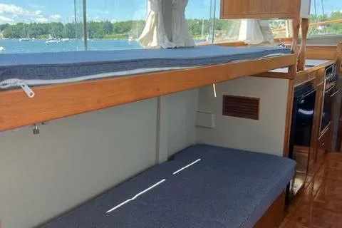 Slide: The Image of 1978 Grand Banks Trawler interior with bunk beds, wooden finish, and scenic window view. - 9