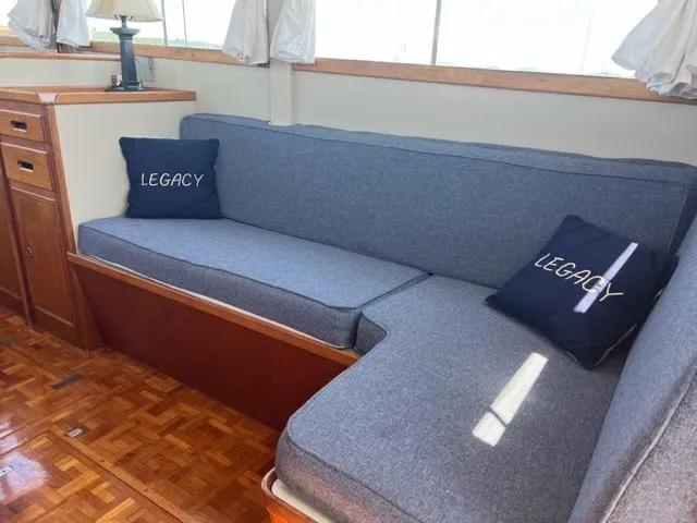 Slide: The Image of 1978 Grand Banks Trawler interior with blue cushions and "Legacy" pillows. - 2