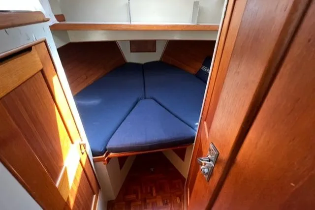 Slide: The Image of 1978 Grand Banks Trawler cabin with blue cushions and wooden interior. - 21