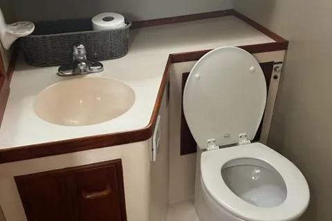Slide: The Image of 1978 Grand Banks Trawler bathroom with sink, toilet, and storage cabinet. - 23