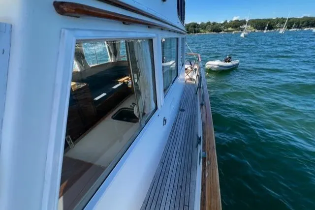 Slide: The Image of 1978 Grand Banks Trawler on water, side view with wooden deck and windows. - 46