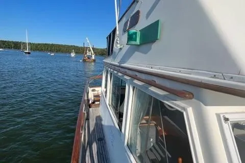 Slide: The Image of 1978 Grand Banks Trawler on calm water, showcasing classic design and wooden details. - 47