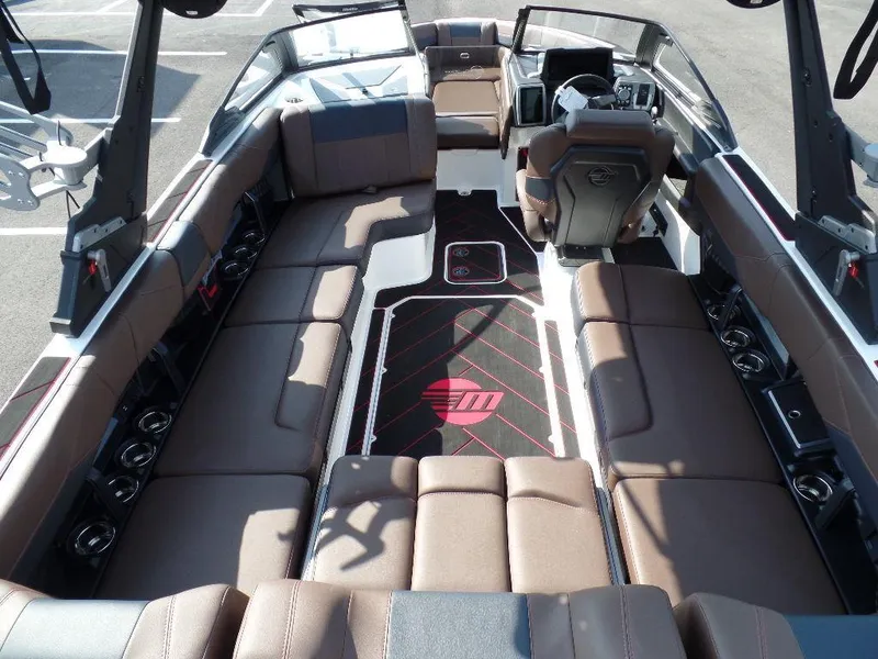 Slide: The Image of 2024 Malibu 23 LSV boat interior with brown seating and modern dashboard design. - 5