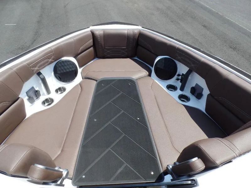Slide: The Image of 2024 Malibu 26 LSV boat interior with brown seating and cup holders. - 10