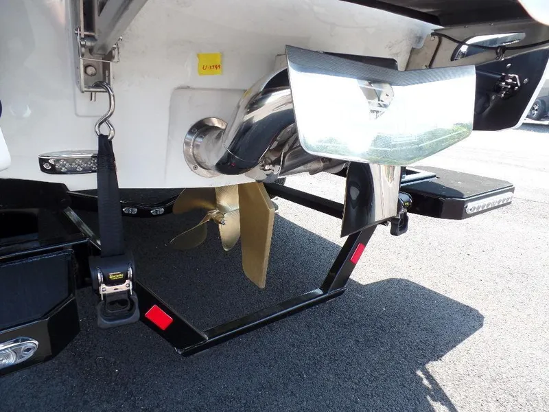 Slide: The Image of 2024 Malibu 26 LSV boat propeller and rudder detail on trailer. - 4
