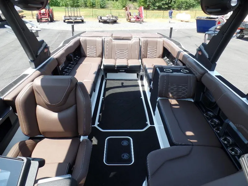 Slide: The Image of 2024 Malibu 26 LSV boat interior with luxurious brown seating and modern design. - 6